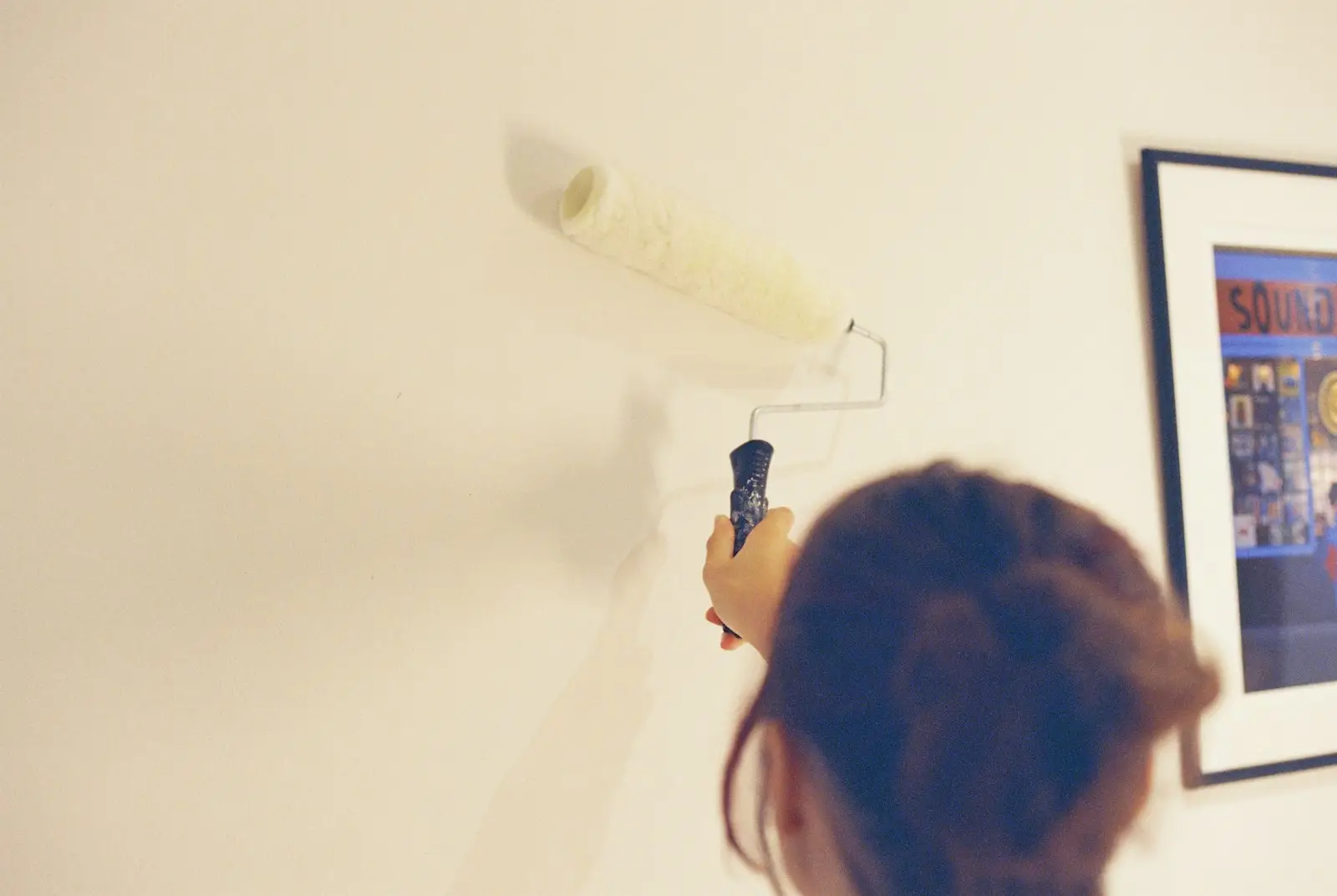 Someone painting a freshly plastered wall with a roller